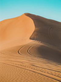 Sand dunes in desert against clear sky