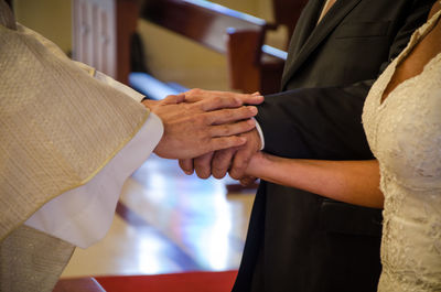 Close-up of priest performing couple wedding in church
