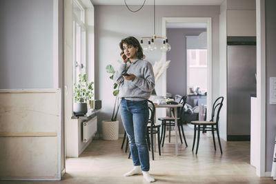 Woman standing at home talking on the phone