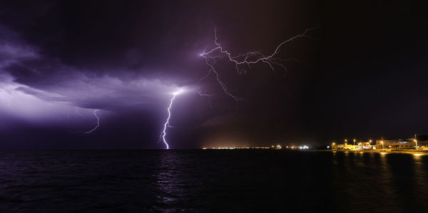 Lightning over sea against sky at night