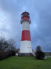 Lighthouse by sea against sky