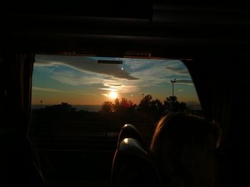 Silhouette man in city against sky during sunset