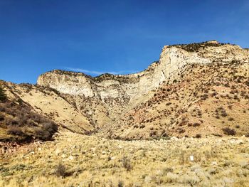 Low angle view of rock formations against clear blue sky