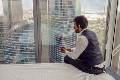 Rear thoughtful businessman with a beard sit ,next to the window in the office skyscrapers in moscow