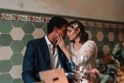 Young couple standing against wall