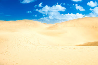 Desert with sand dunes and clouds on blue sky. landscape of maspalomas dunes. gran canaria, spain