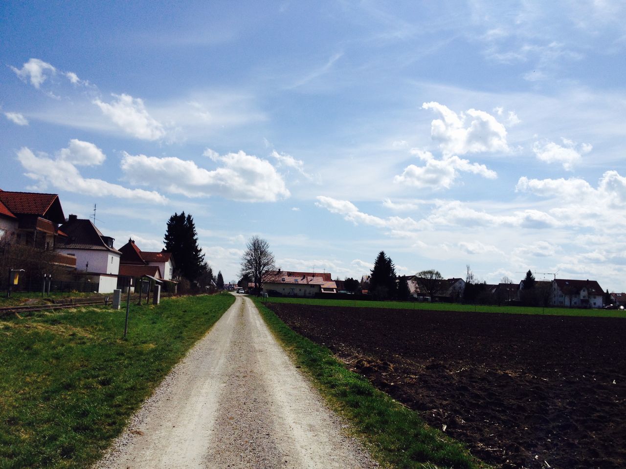 the way forward, building exterior, sky, architecture, built structure, diminishing perspective, grass, cloud - sky, vanishing point, road, cloud, tree, walkway, transportation, field, house, dirt road, street, pathway, footpath