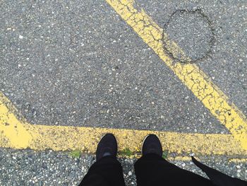 Low section of man standing on road