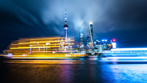 Illuminated buildings against sky at night