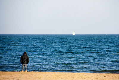 Rear view of man on sea against sky