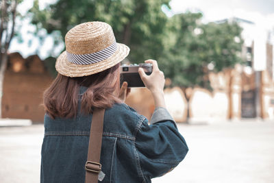 Midsection of woman photographing with mobile phone in city