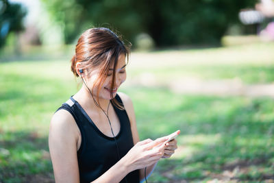 Midsection of woman using smart phone outdoors