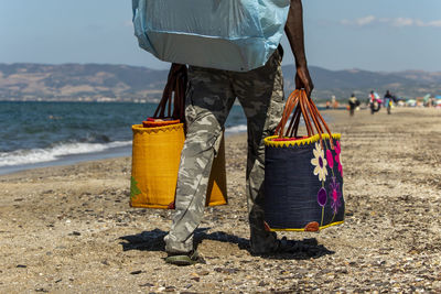 Low section of man standing on beach