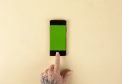 Cropped hand of woman holding box against pink background