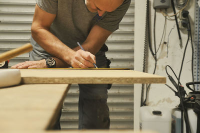 Midsection of carpenter working at workshop