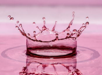 Close-up of splash crown against pink background