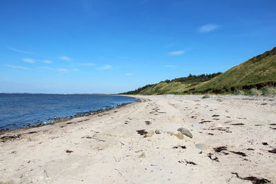 Scenic view of beach against blue sky