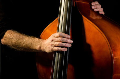 Cropped hand of man playing double bass