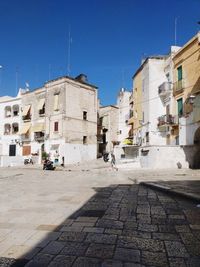 Street amidst buildings in town against clear blue sky