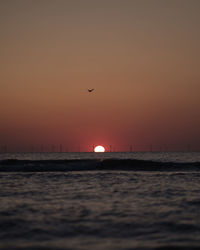 Scenic view of sea against orange sky