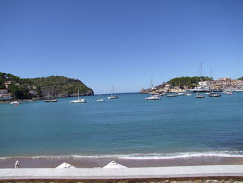 Sailboats in sea against clear blue sky