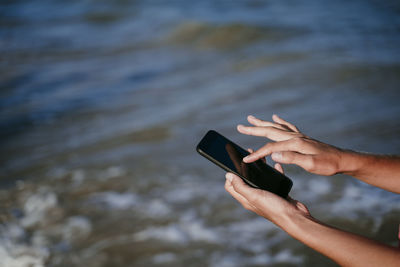 Midsection of man using mobile phone