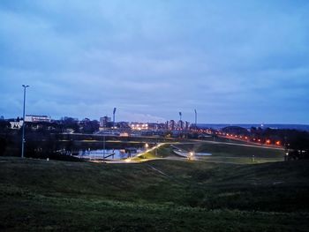 Illuminated city against sky at dusk