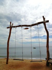 Clothes hanging on beach against sky