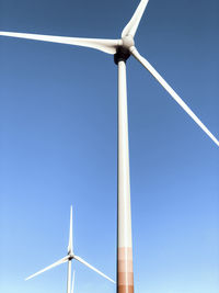 Low angle view of windmill against clear blue sky