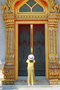 Female taking photo of ordination hall door  of wat benchamabophit marble temple, bangkok, thailand