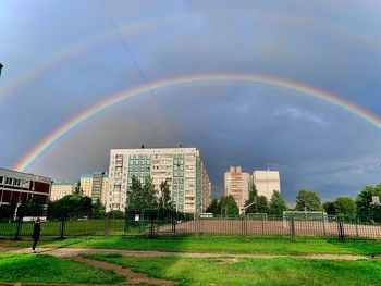 Rainbow over buildings against sky