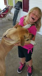 Girl with dog standing on floor