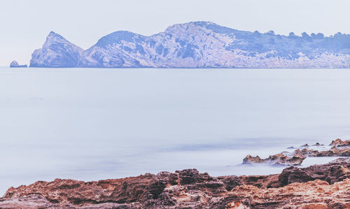 Scenic view of snowcapped mountains by sea against sky