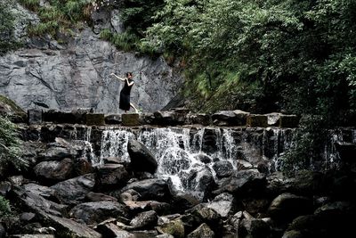 Rear view of man standing on rock