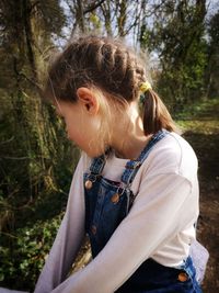 Side view of young woman in forest