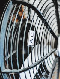 Cropped image of electric fan with text on metal grate