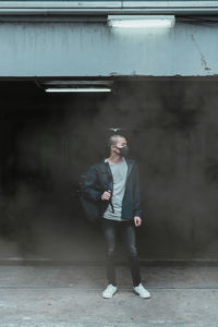 Full length of young man standing against wall