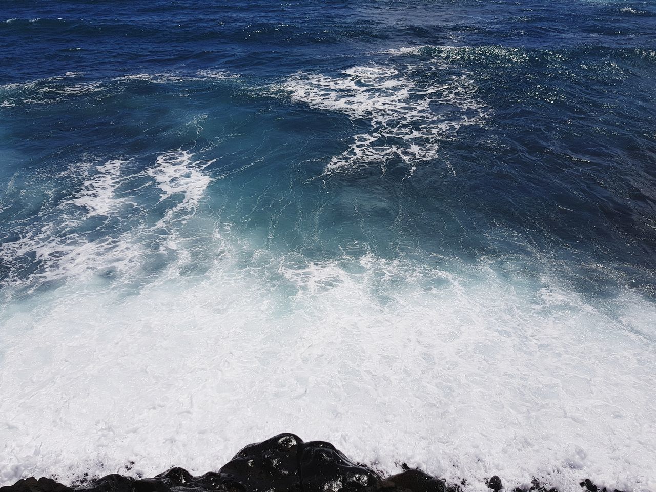 HIGH ANGLE VIEW OF WAVES SPLASHING ON SHORE