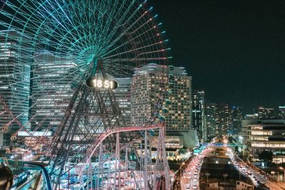 Low angle view of illuminated ferris wheel against sky at night