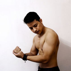 Shirtless muscular man posing against white background