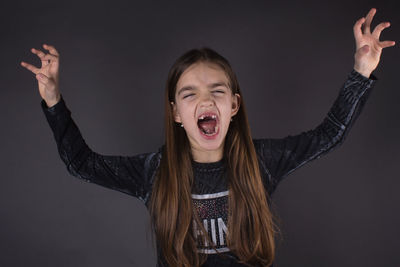 Portrait of girl standing against gray background