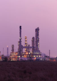 Illuminated factory against sky at night