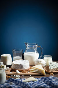 Dairy products on wood base and blue background with copy space. vertical format.