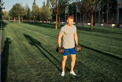 Full length of man wearing sunglasses on grass against trees