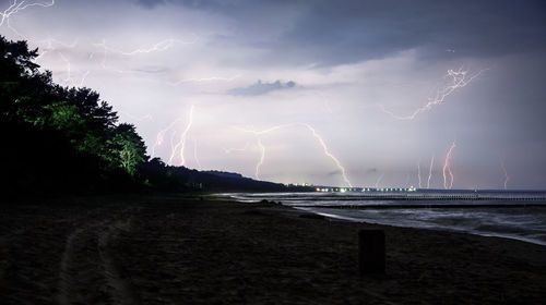 Scenic view of sea against storm clouds at dusk