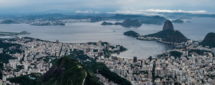 High angle view of townscape by sea against sky