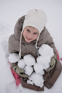 Portrait of smiling girl with snow during winter