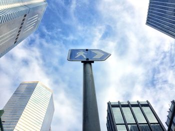 Low angle view of office buildings against cloudy sky