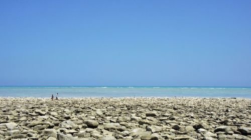 Scenic view of beach against clear blue sky