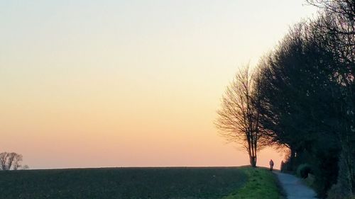 Scenic view of field against clear sky during sunset